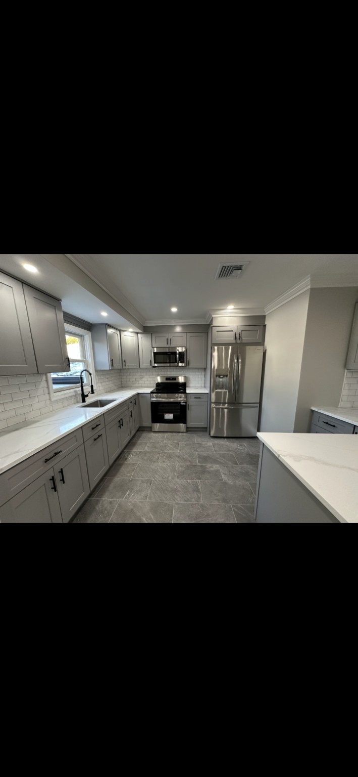 Completed grey Shaker kitchen renovation with stainless appliances