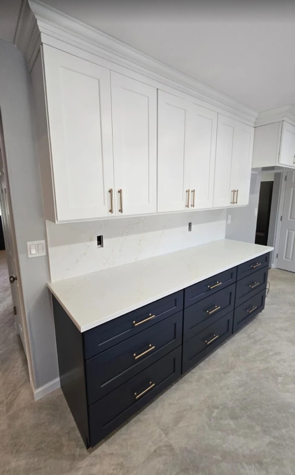 Completed two-tone navy and white Shaker cabinet wall with gold hardware