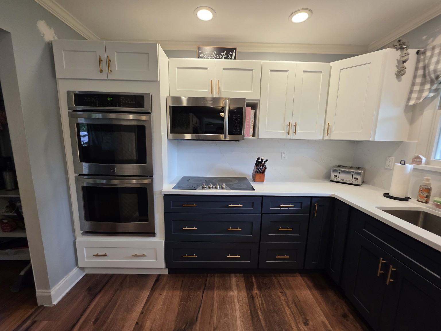 Completed navy base cabinets and white wall cabinets with gold hardware
